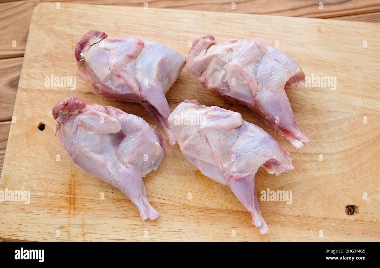 Quails on a cutting board. Thawed poultry preparing for cooking. Stock Photo
