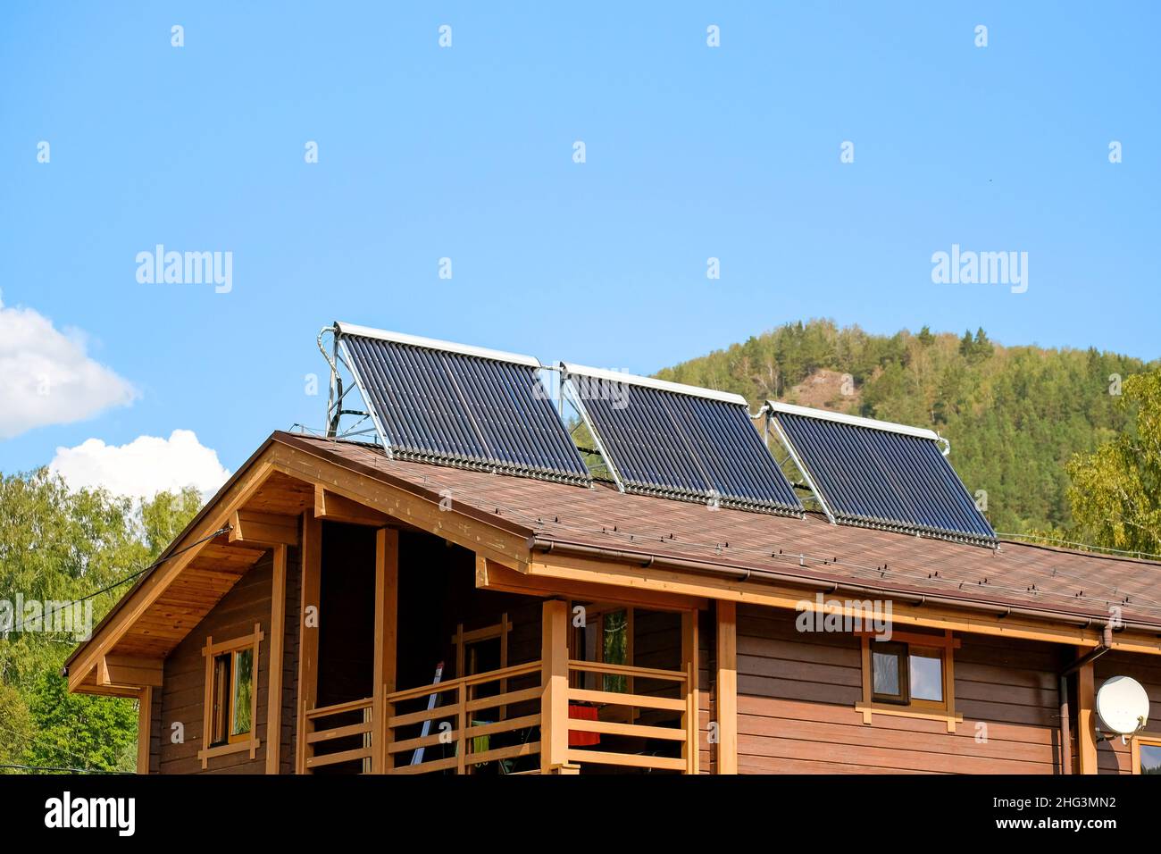 Eco-friendly rooftop installation for energy production. Wooden house. Stock Photo