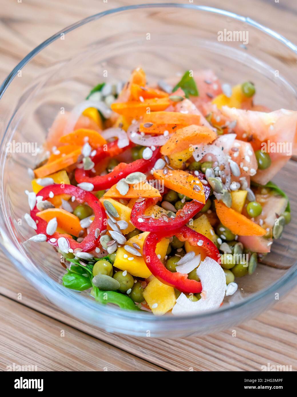 Vegetable colorful bright salad in a transparent bowl. Stock Photo