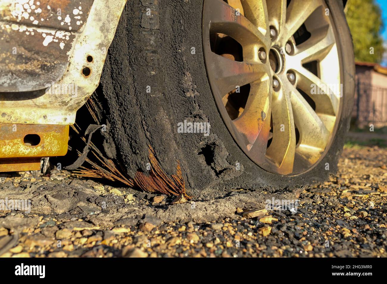 A wheel of a burnt-out car. Remains of the car. Stock Photo