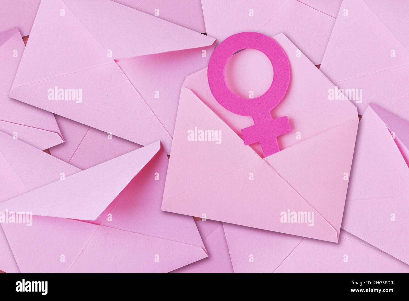 Pile of pink envelopes with female gender symbol - Concept of mailing and woman Stock Photo