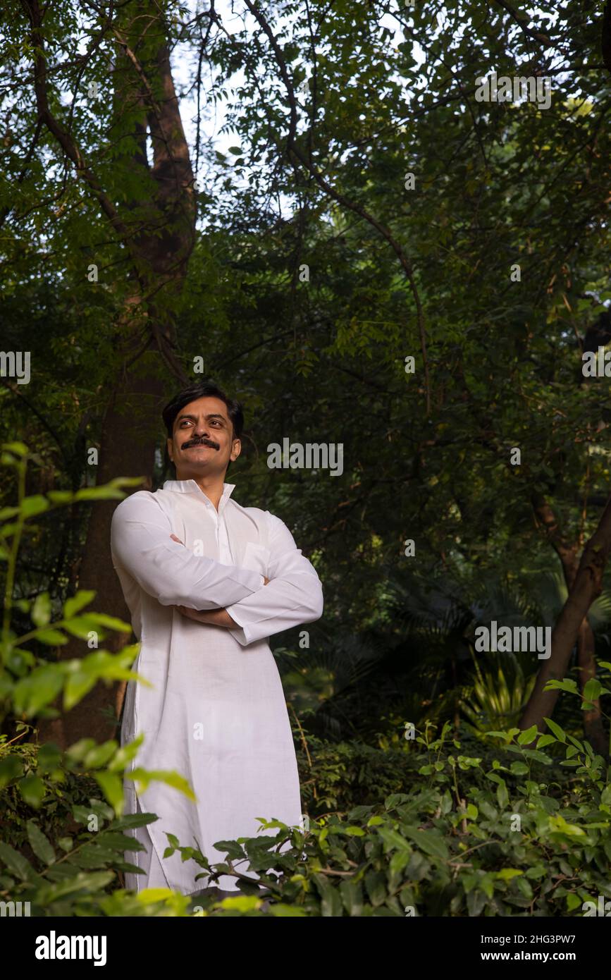 Man in white kurta standing in park in the morning Stock Photo