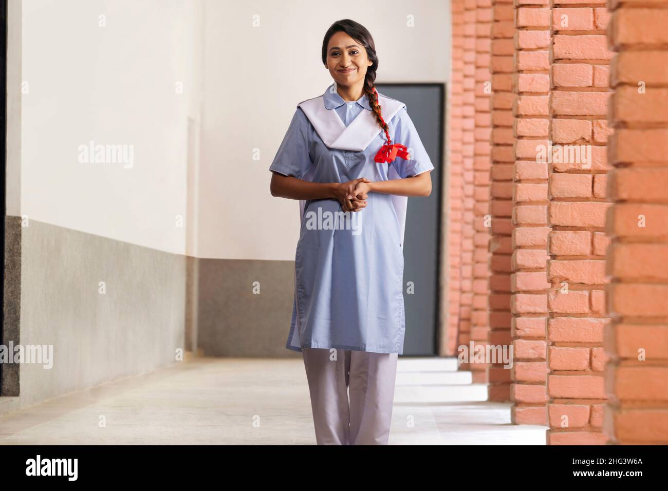 Portrait of a school girl standing in school corridor Stock Photo - Alamy