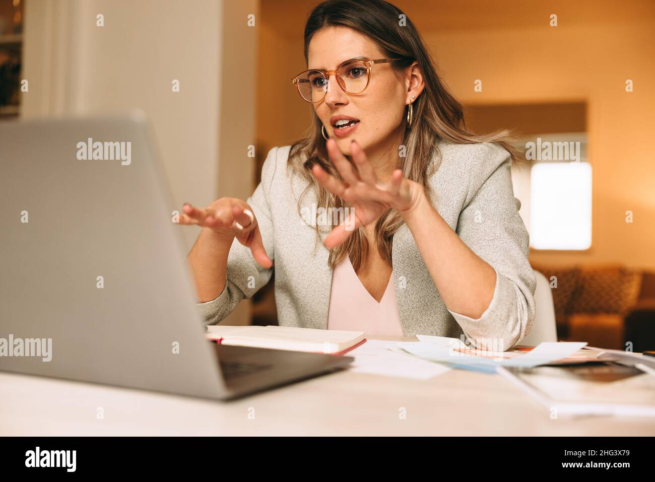 Smart interior designer explaining her plans during a virtual meeting. Creative businesswoman video calling her clients using a laptop. Female designe Stock Photo