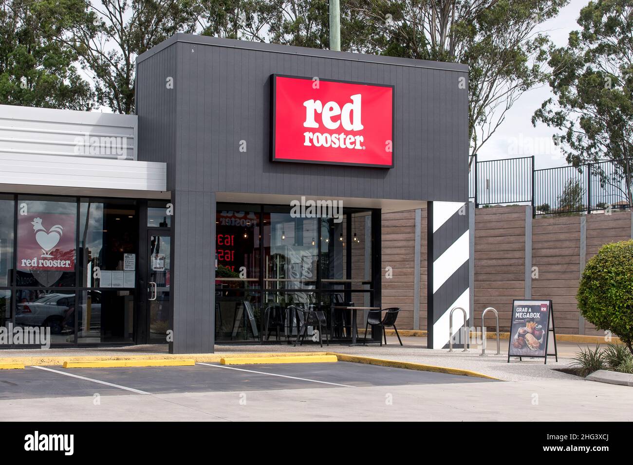 Red Rooster fast food (chicken) outlet at petrol station in Beaudesert, Queensland, Australia. Big red sign, Australian franchise. Stock Photo