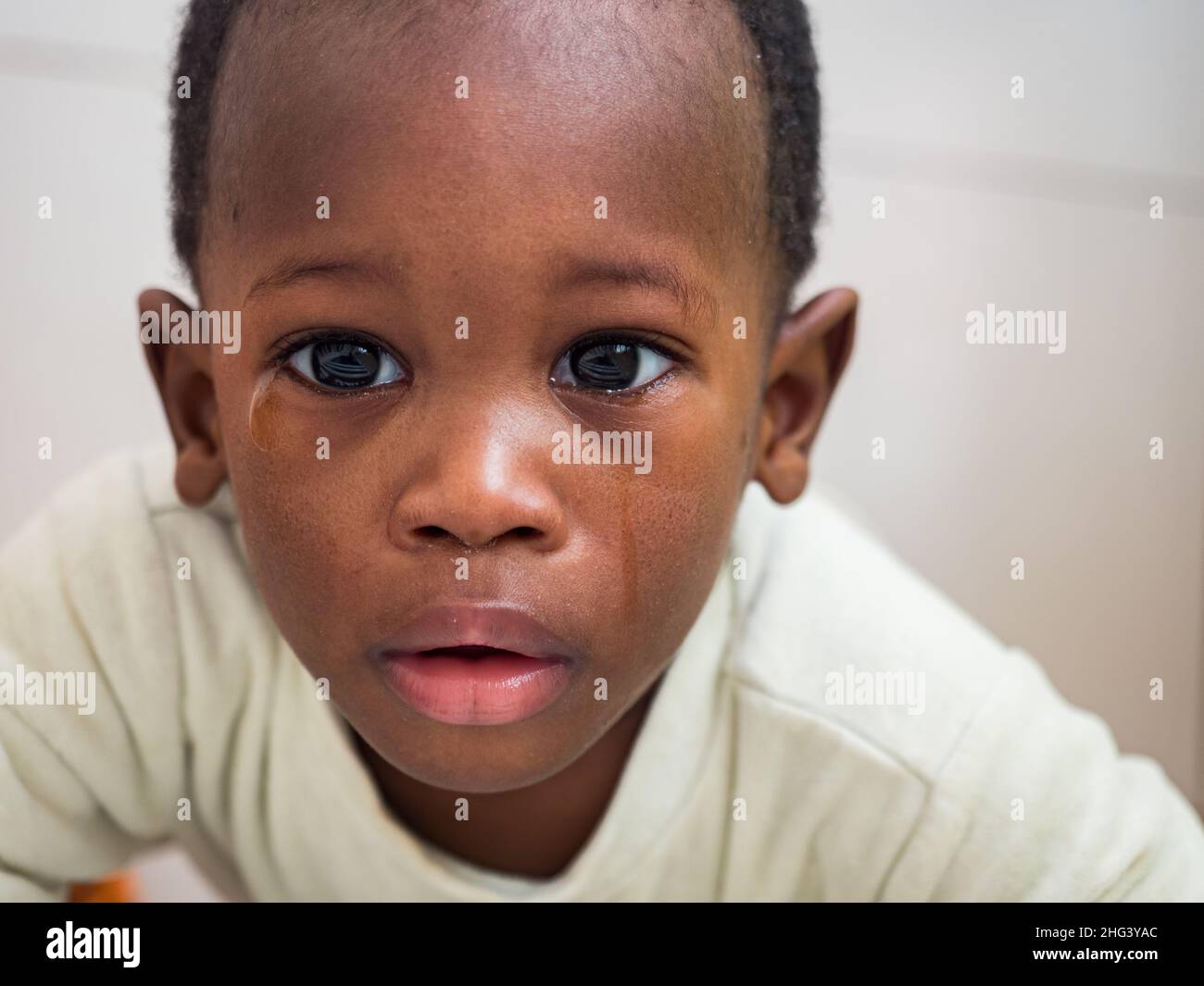 Senegal, Africa - January 24, 2019: Portrait of a small black crying boy with a big eyes . Stock Photo