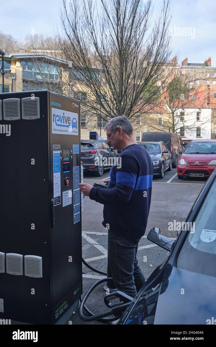 Driver pays to charge his car at an EV charging point in bristol England Stock Photo