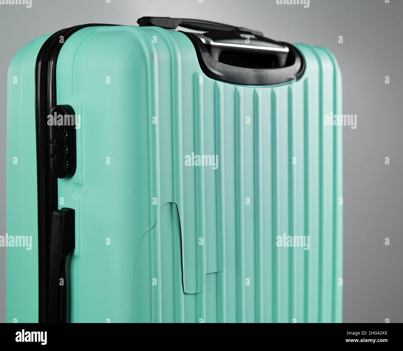 Closeup of a broken suitcase on a white background. Damaged baggage