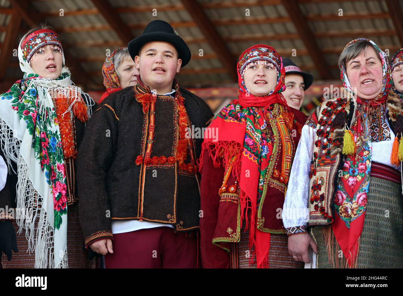 VERKHOVYNA, UKRAINE - JANUARY 16, 2022 - A boy surrounded by women sing ...