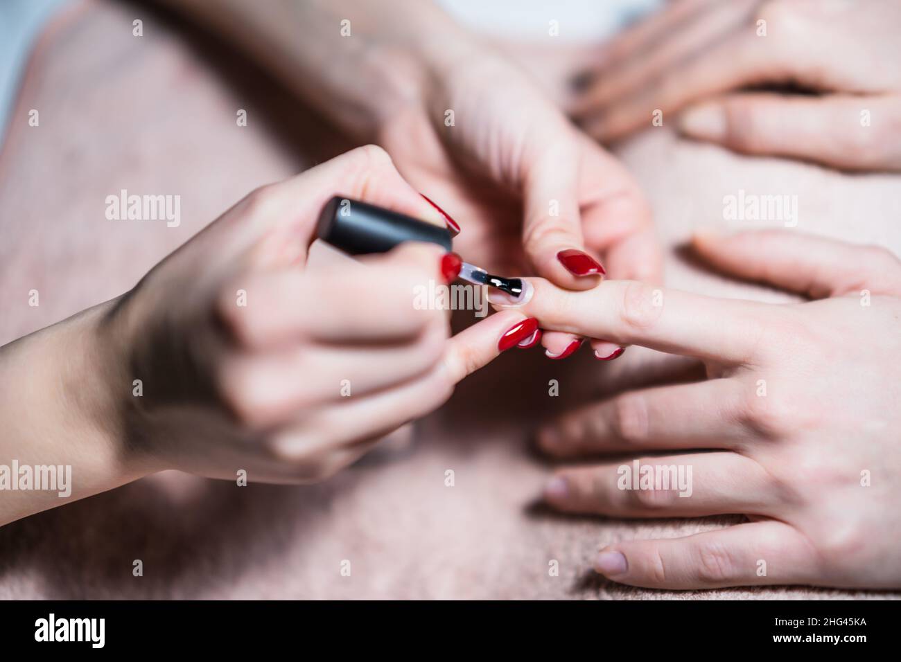 Close up image of manicure process, manicurist applying gel nail polish
