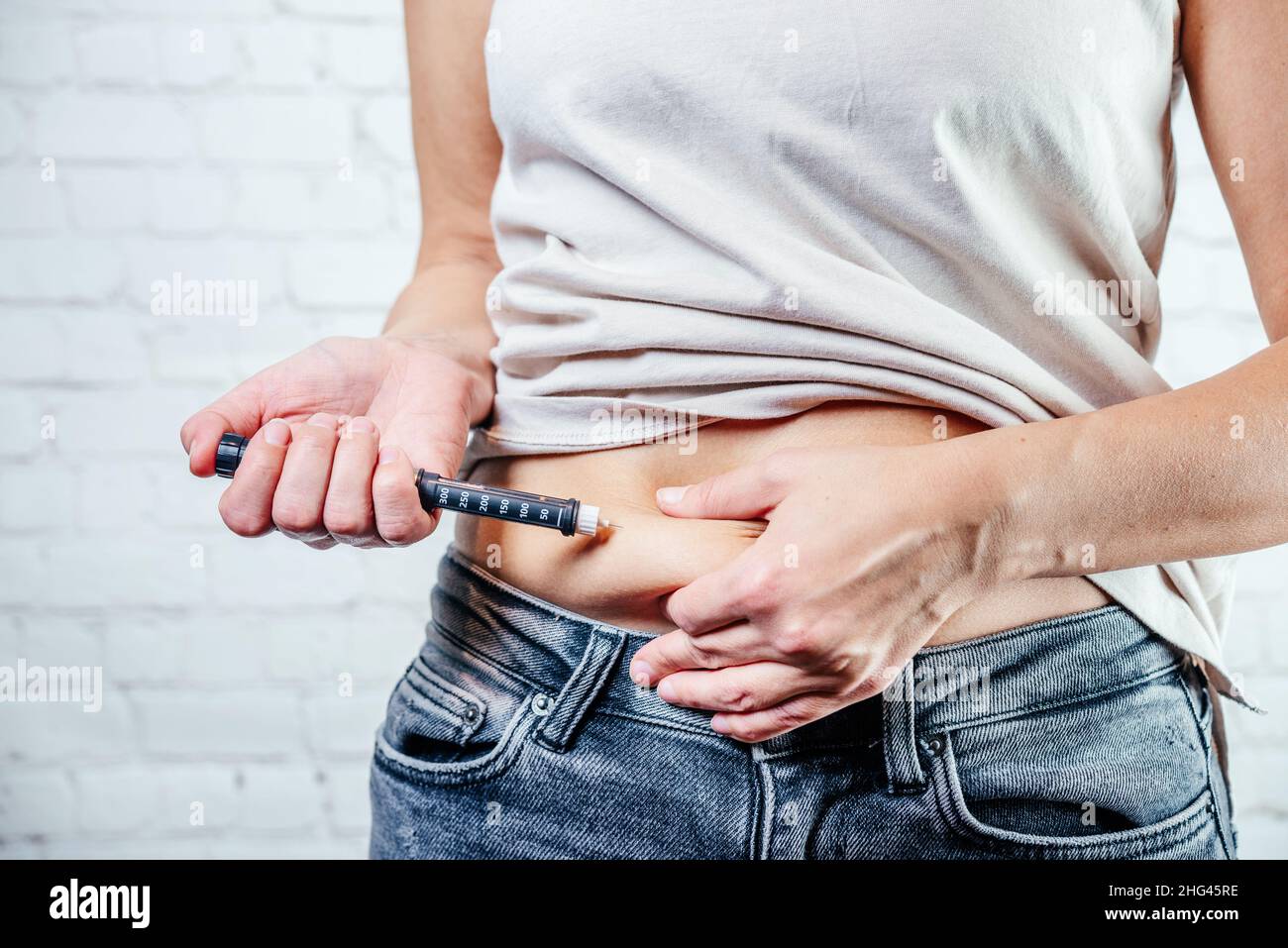 A woman injects insulin with insulin injection device into the