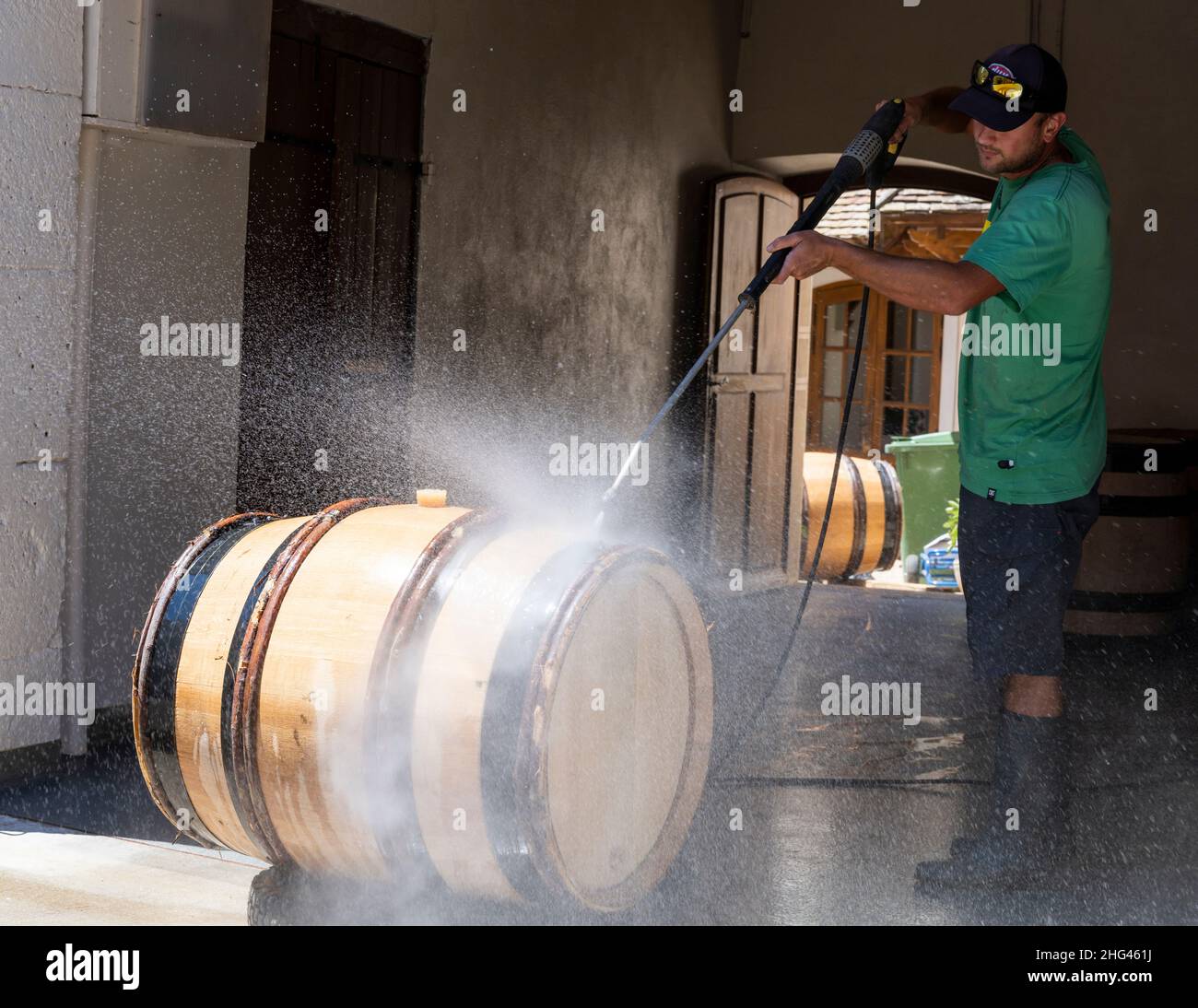 Monthelie, France - June 30, 2020: Cleaning wine barrels on the street in front of the clos in Monthelie in burgundy with pressure washer, France. Stock Photo