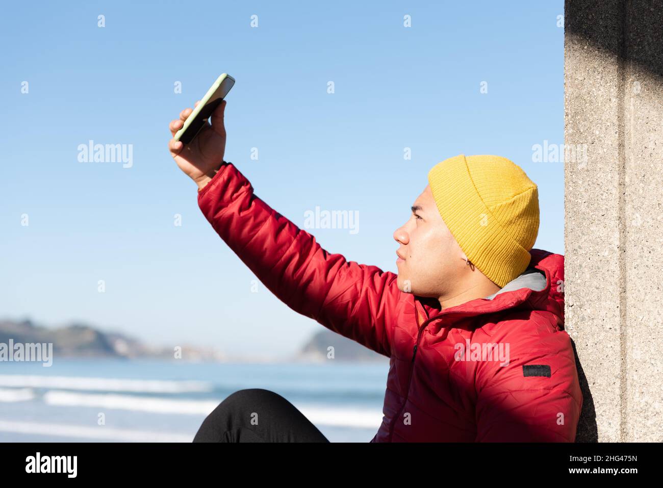 Young latin man taking a selfie or recording himself Stock Photo