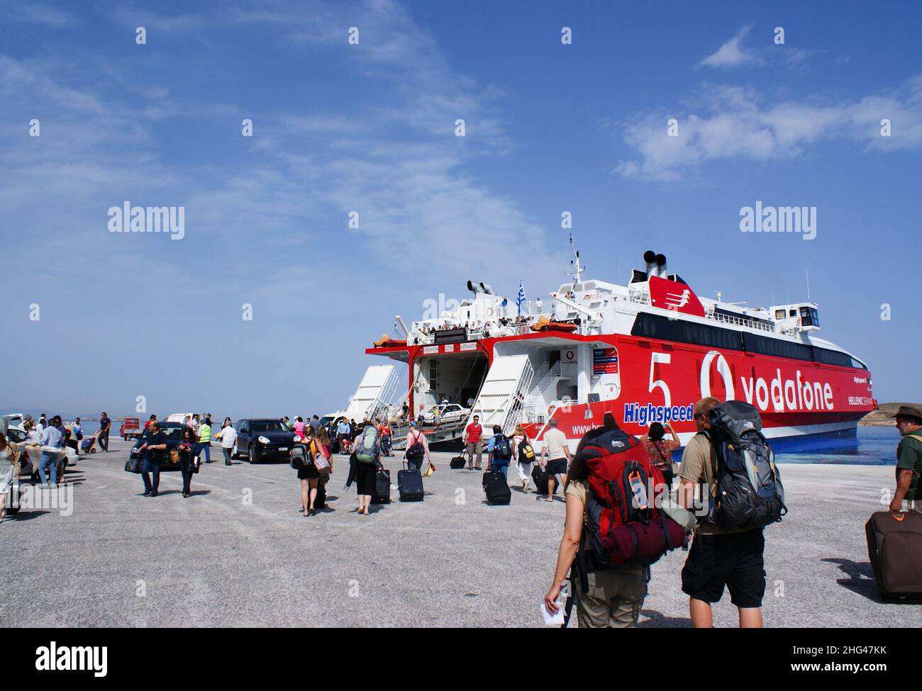 Paros island - Greece - May 13 2010 : Bustling Greek port of Parikia. Travellers board the inter island ferry, docked at the harbor.  Landscape aspect Stock Photo
