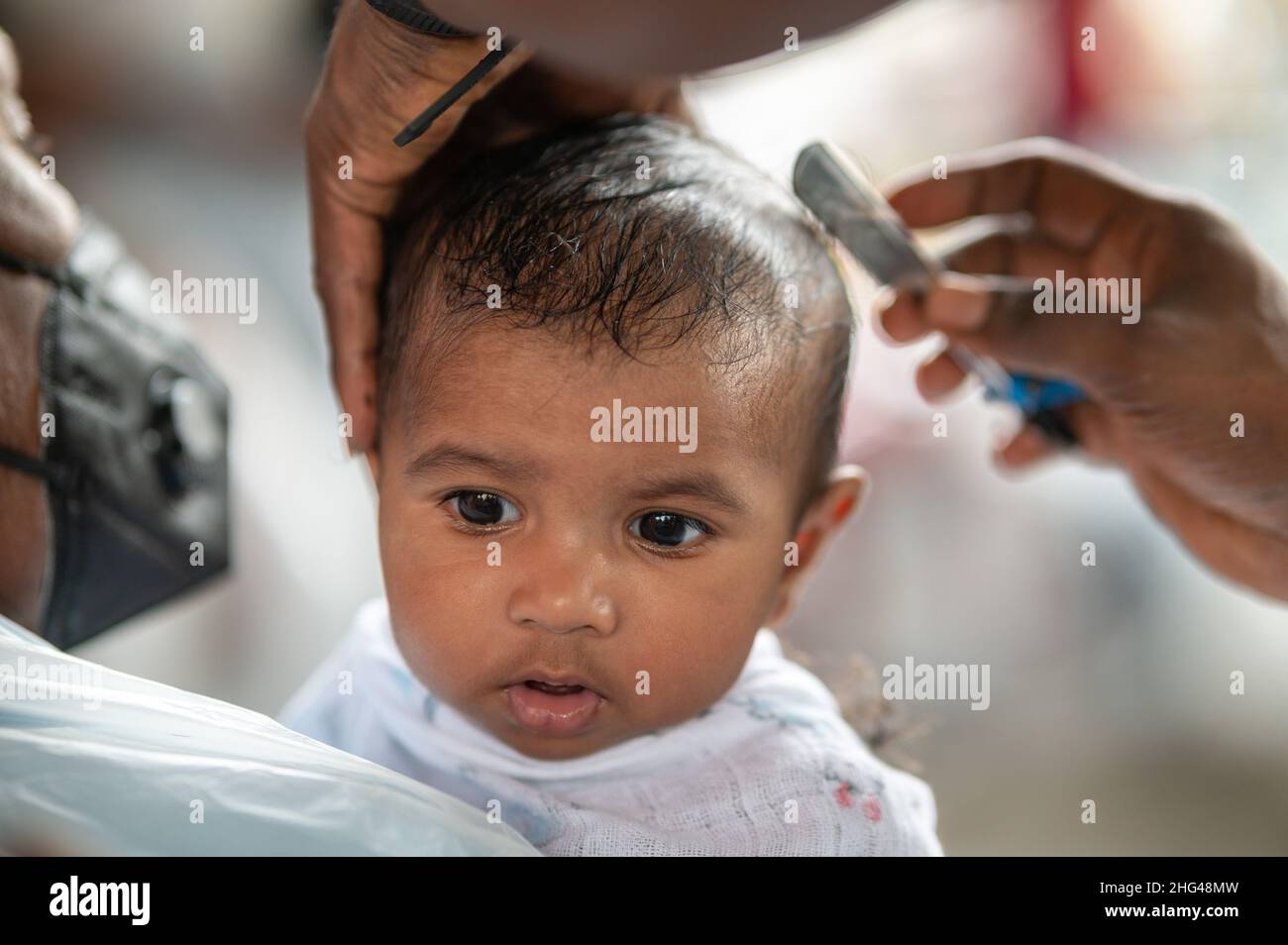 Kuala Lumpur, Malaysia. 18th Jan, 2022. A child gets his hair cut in a  barber shop as Hindu devotees celebrate the Thaipusam festival at Batu  Caves on the outskirts of Kuala Lumpur,