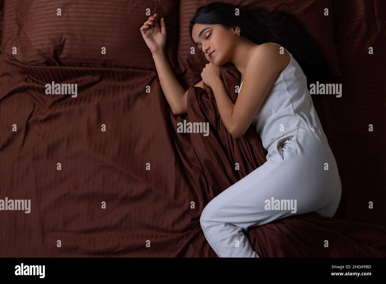 Portrait of a young girl sleeping on bed Stock Photo