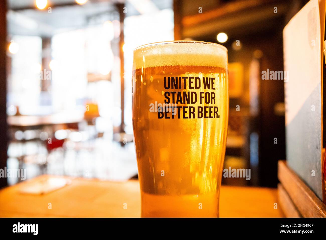 Newcastle UK - 18th Oct 2021 - Pint of craft beer in a Brewdog bar, no logos. United We Stand for Better Beer caption on full glass Stock Photo