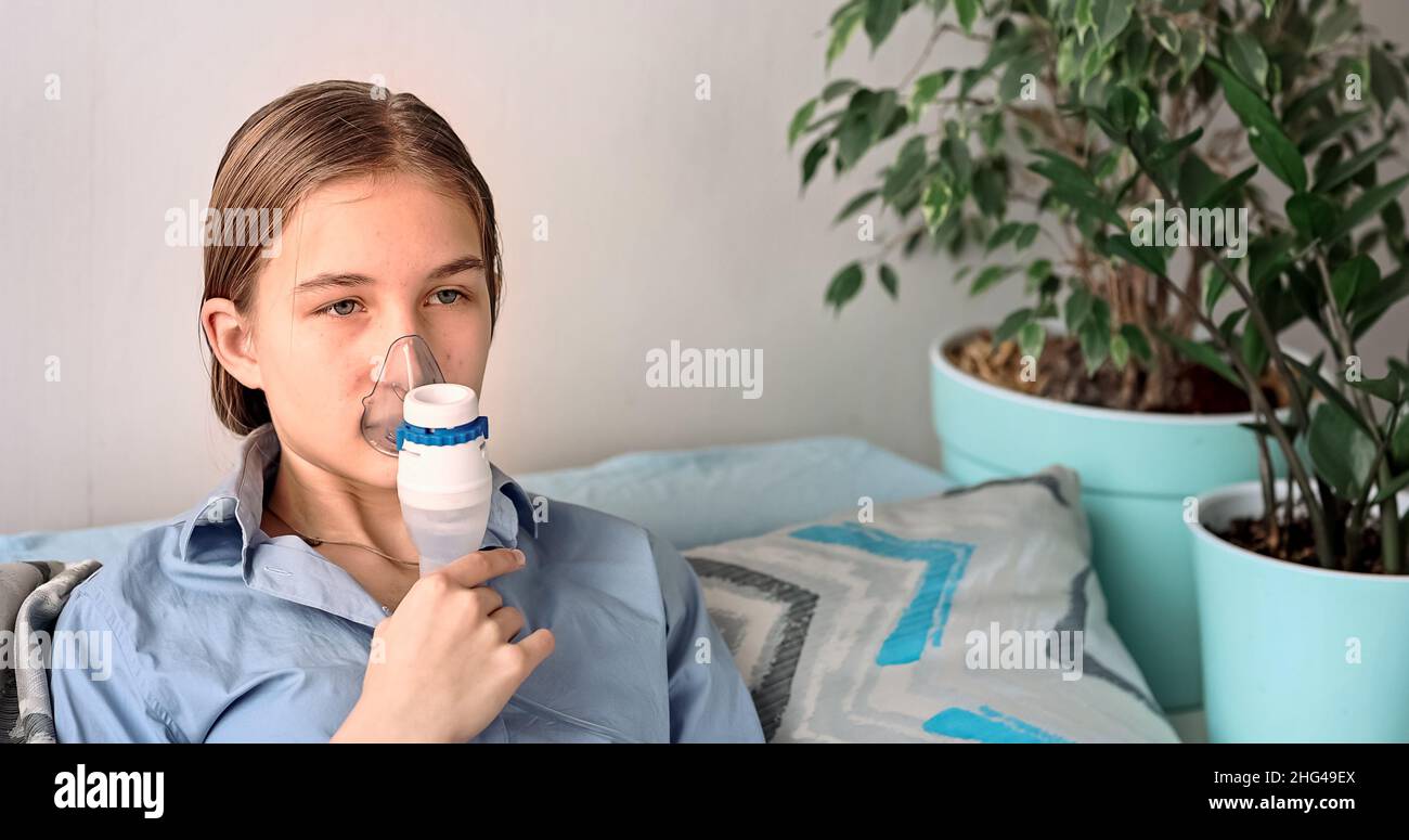 Teenage girl makes inhalation with a nebulizer equipment. Sick child