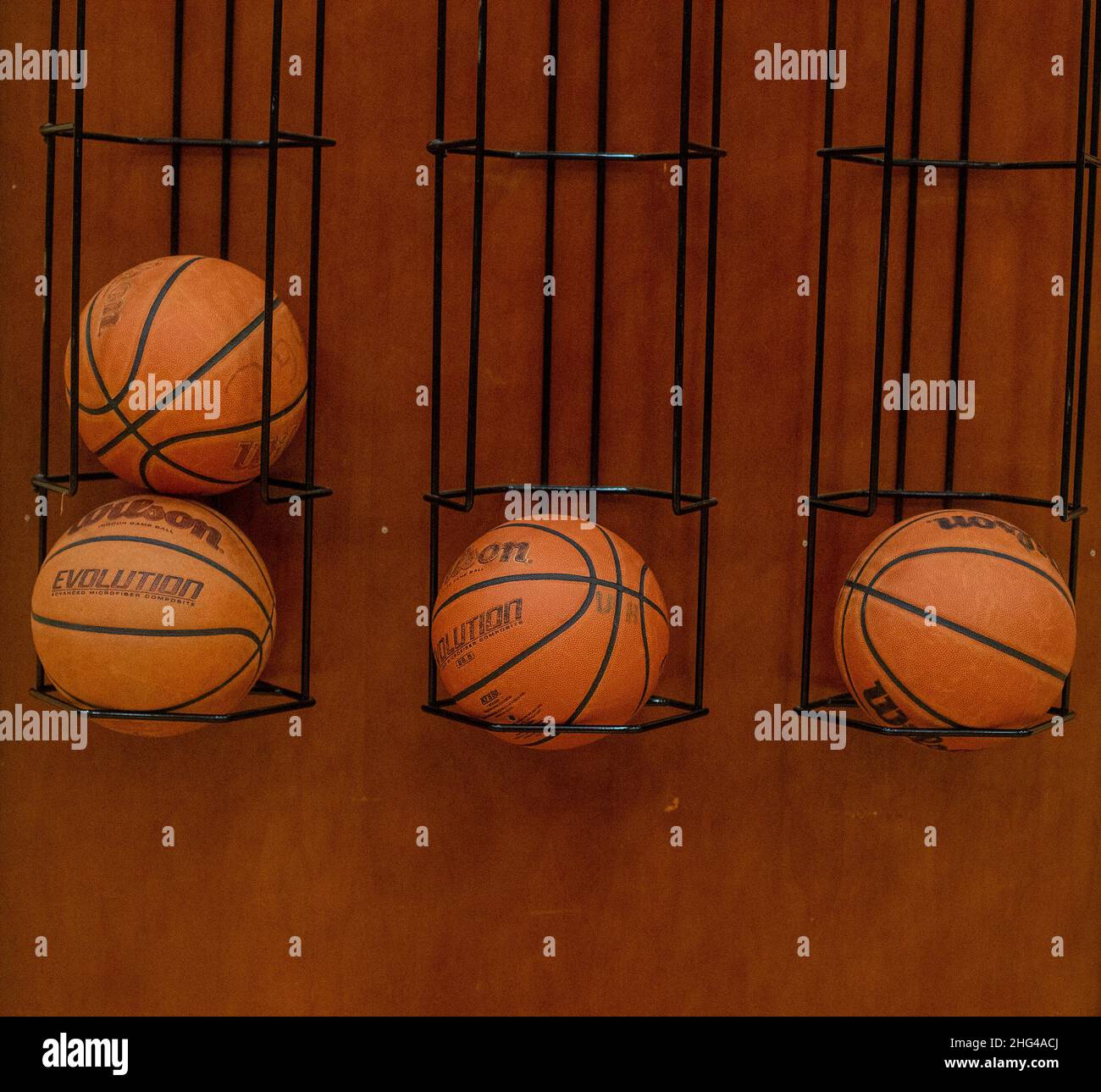 Basketballs on a rack at a high school gym Stock Photo
