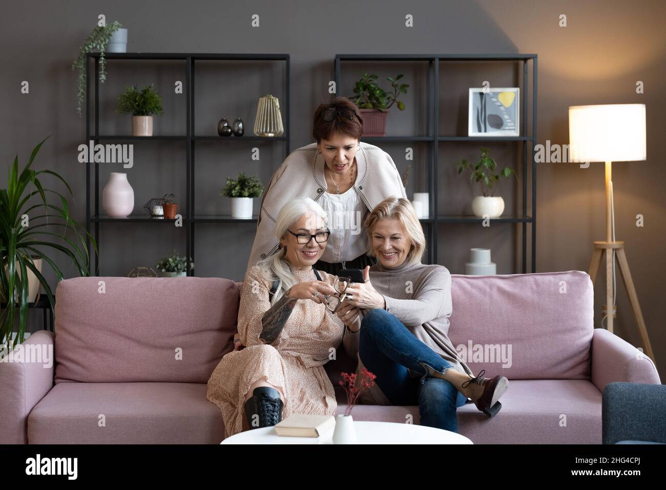 Group of mature women watching something on mobile phone and smiling ...