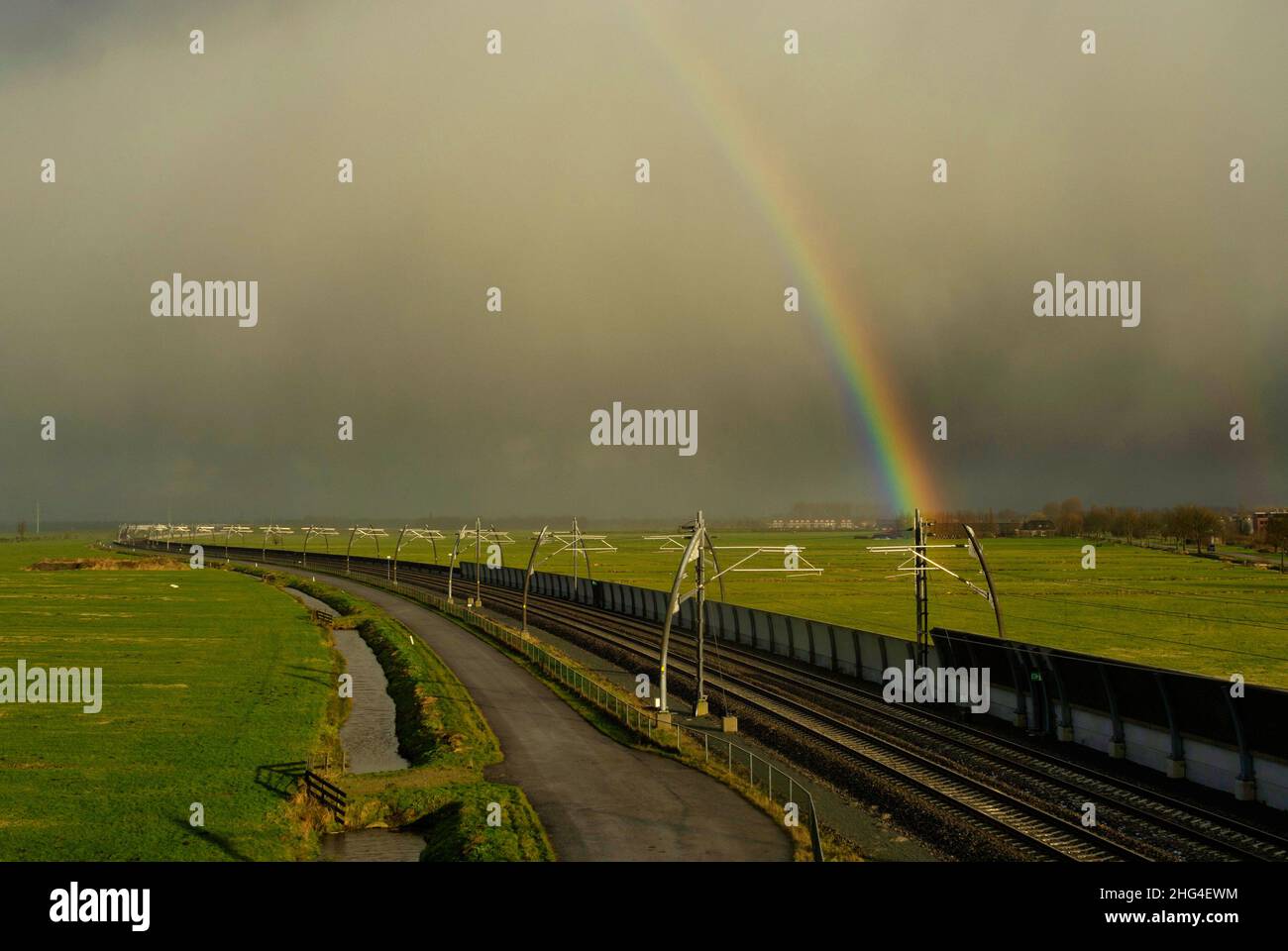 Rainbow above an empty railroad track near Sliedrecht Stock Photo