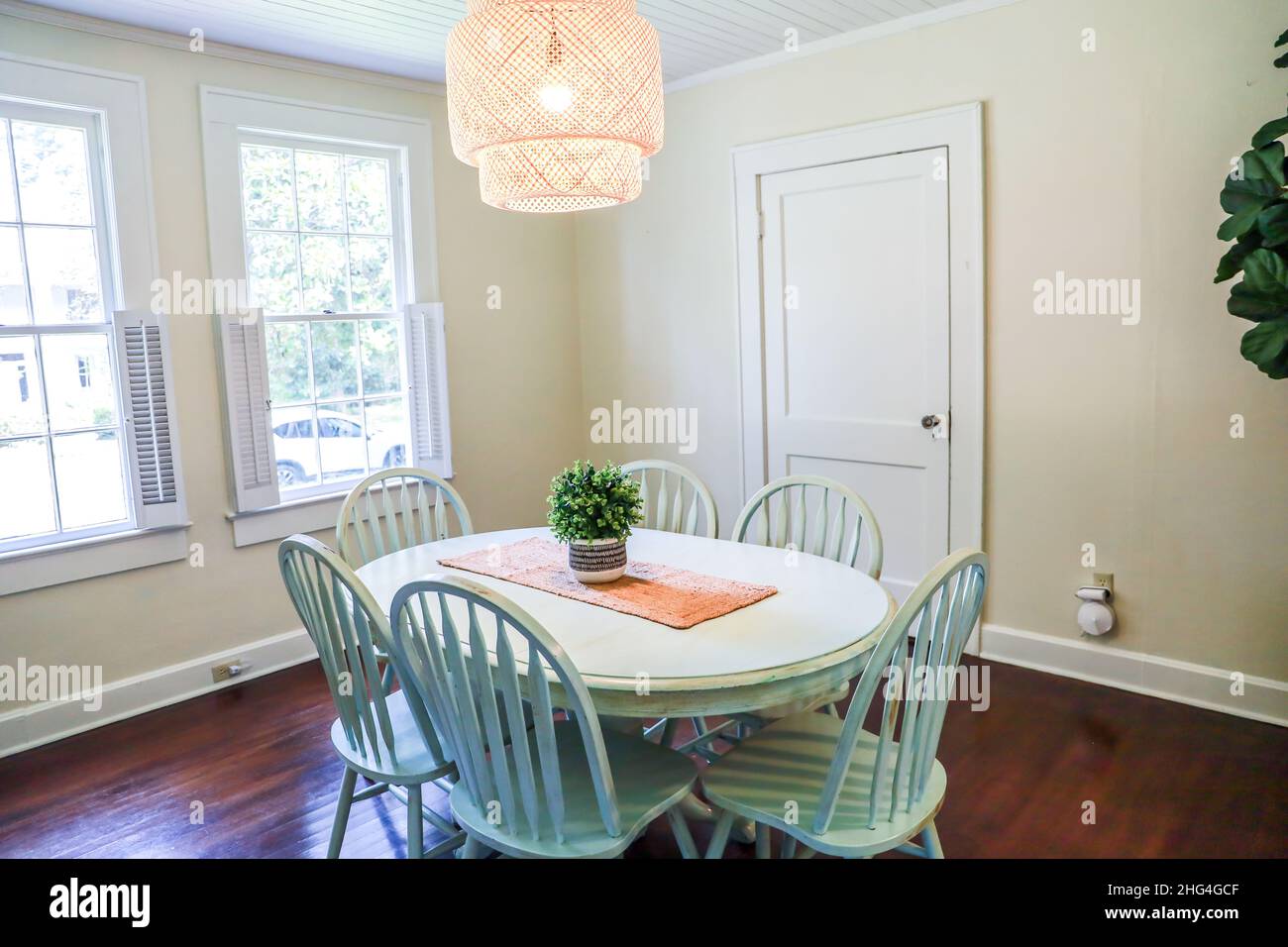 A small dining room with a statement rattan lighting fixture Stock