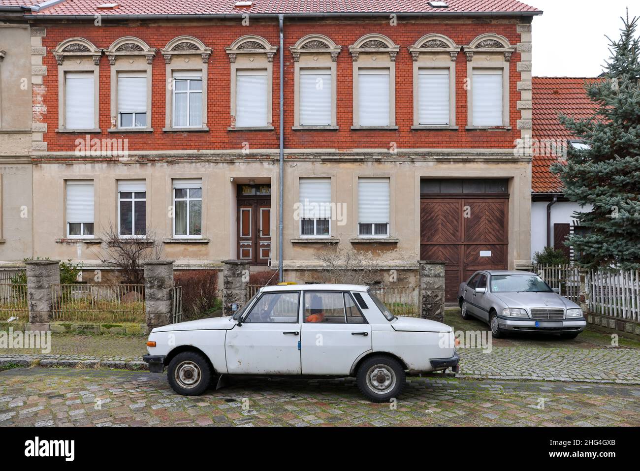 18 January 2022, Saxony-Anhalt, Dessau-Roßlau: A Wartburg 353 stands next to a Mercedes C-Class of the first series W202 in a small cobblestone street in the Rosslau district. The former dream car from the VEB Automobilwerk Eisenach is rarely seen on the road anymore. 30 years after production was halted in April 1991, 8361 Wartburgs were registered in Germany, according to the Federal Motor Transport Authority. A good 1.2 million cars of the brand were built between 1955 and 1991. Photo: Jan Woitas/dpa-Zentralbild/dpa Stock Photo