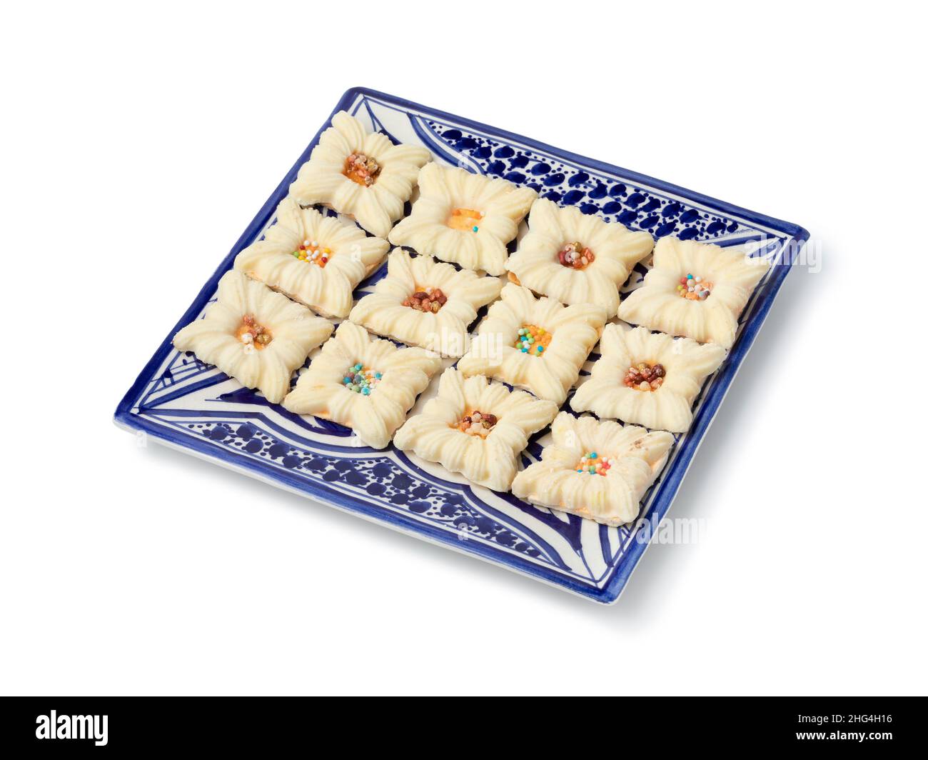Traditional Moroccan plate with decorated white chocolate cookies isolated on white background for ramadan or Ashura Stock Photo
