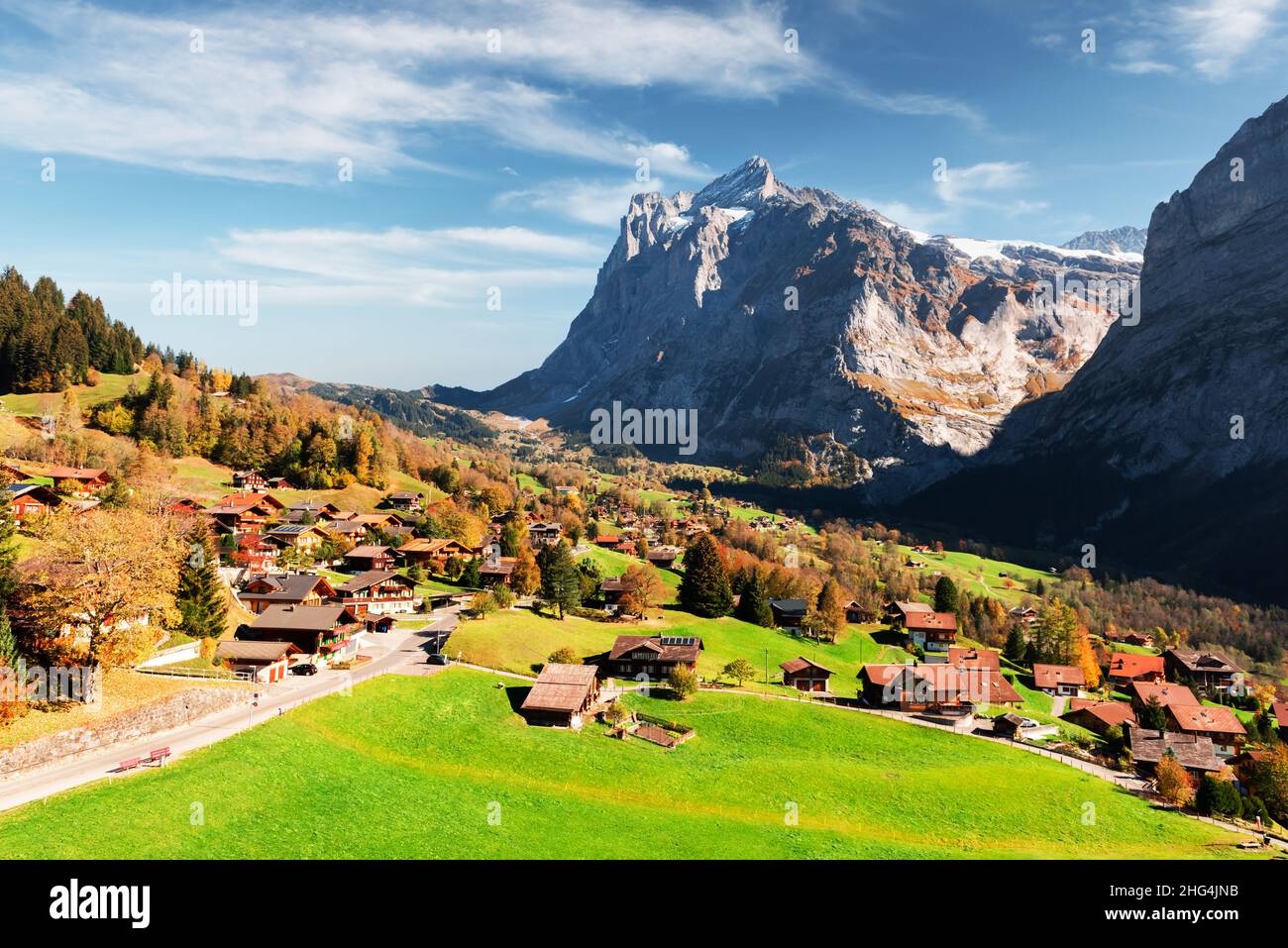 Picturesque autumn landscape in Switzerland mountains. Yellow leaves and wooden houses in Grindelwald village in Swiss Alps Stock Photo