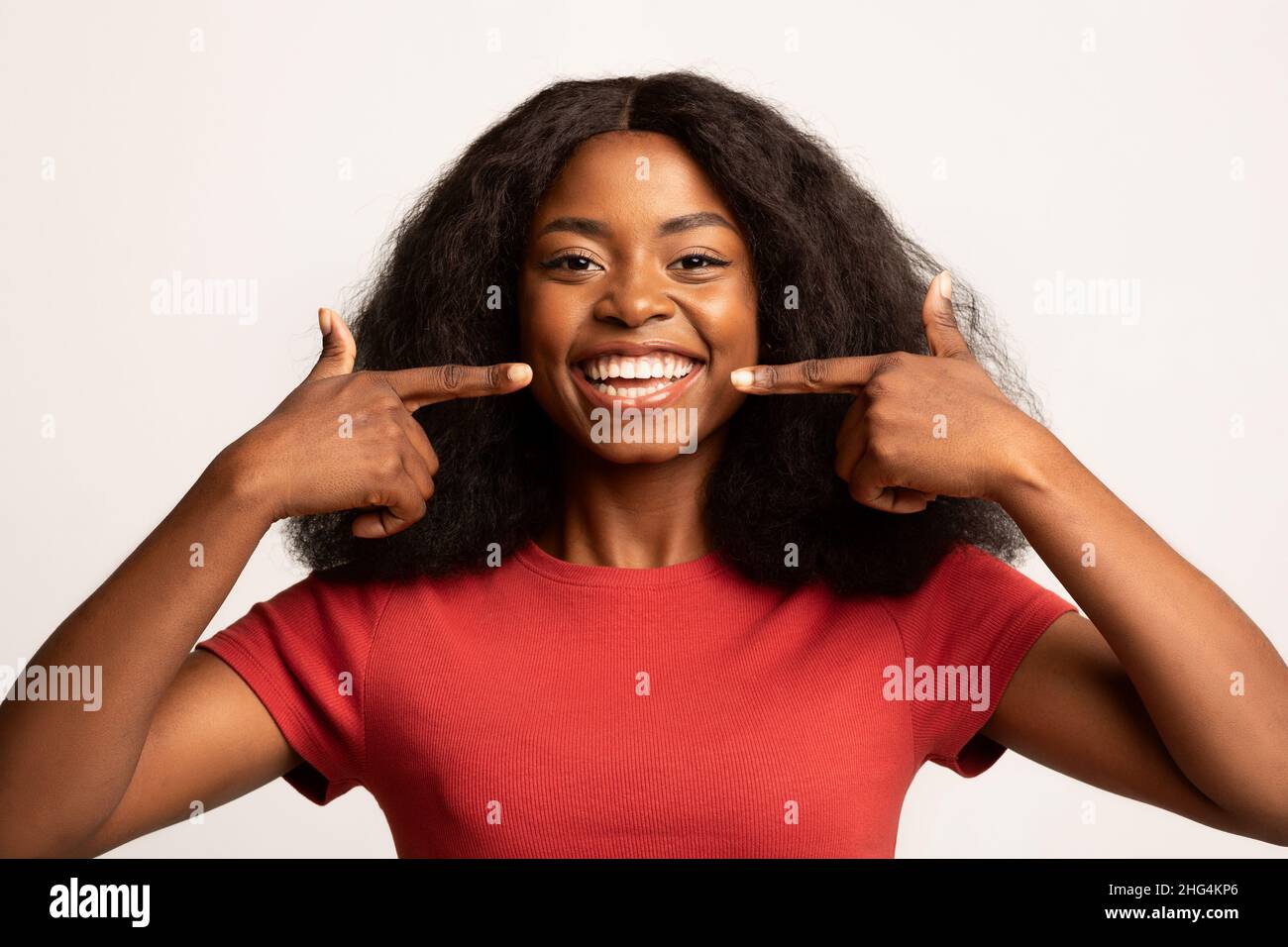 Dental Health. Beautiful Young African American Woman Pointing At Her Smile Stock Photo