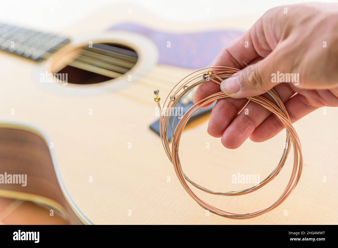 The musician replace the new guitar strings for his guitar Stock Photo