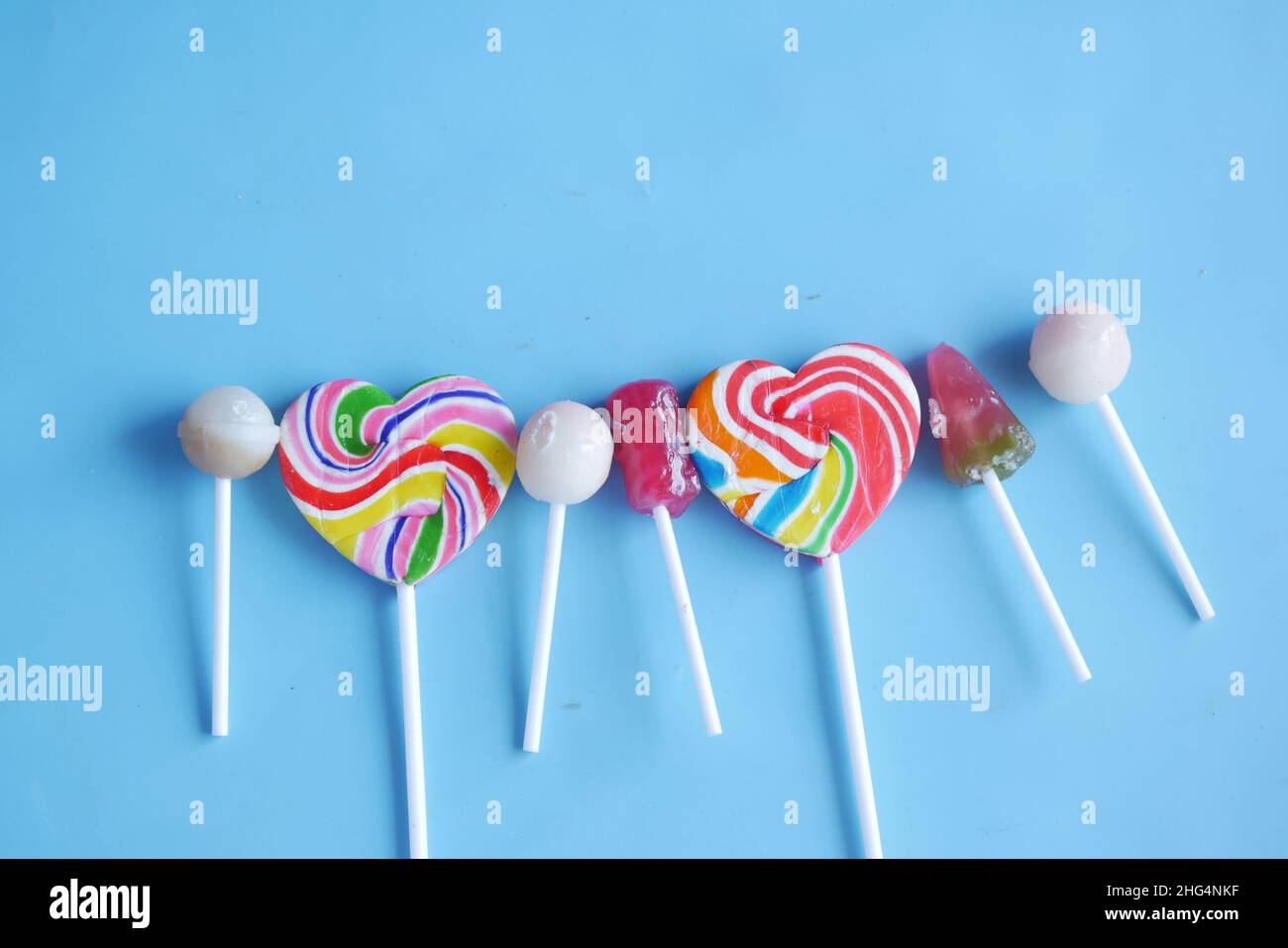 rainbow heart shape lollipop on blue background  Stock Photo