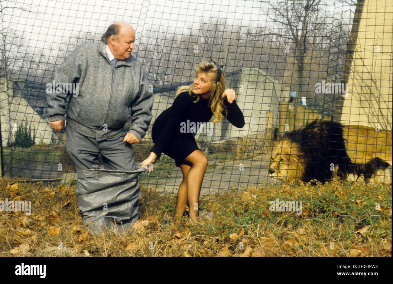 Comedian Roy Kinnear with page three model Suzanne Mizzi at London Zoo in Regents Park, watched by caged feline Dax. Stock Photo