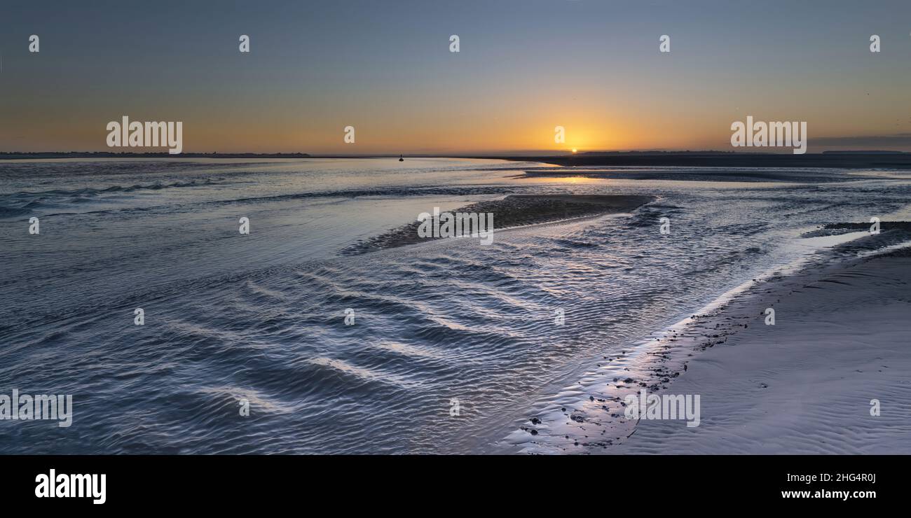Baie de Somme, le Hourdel, chenal à marée basse, blockhaus, coucher de soleil sur la mer , sable et balises. Stock Photo