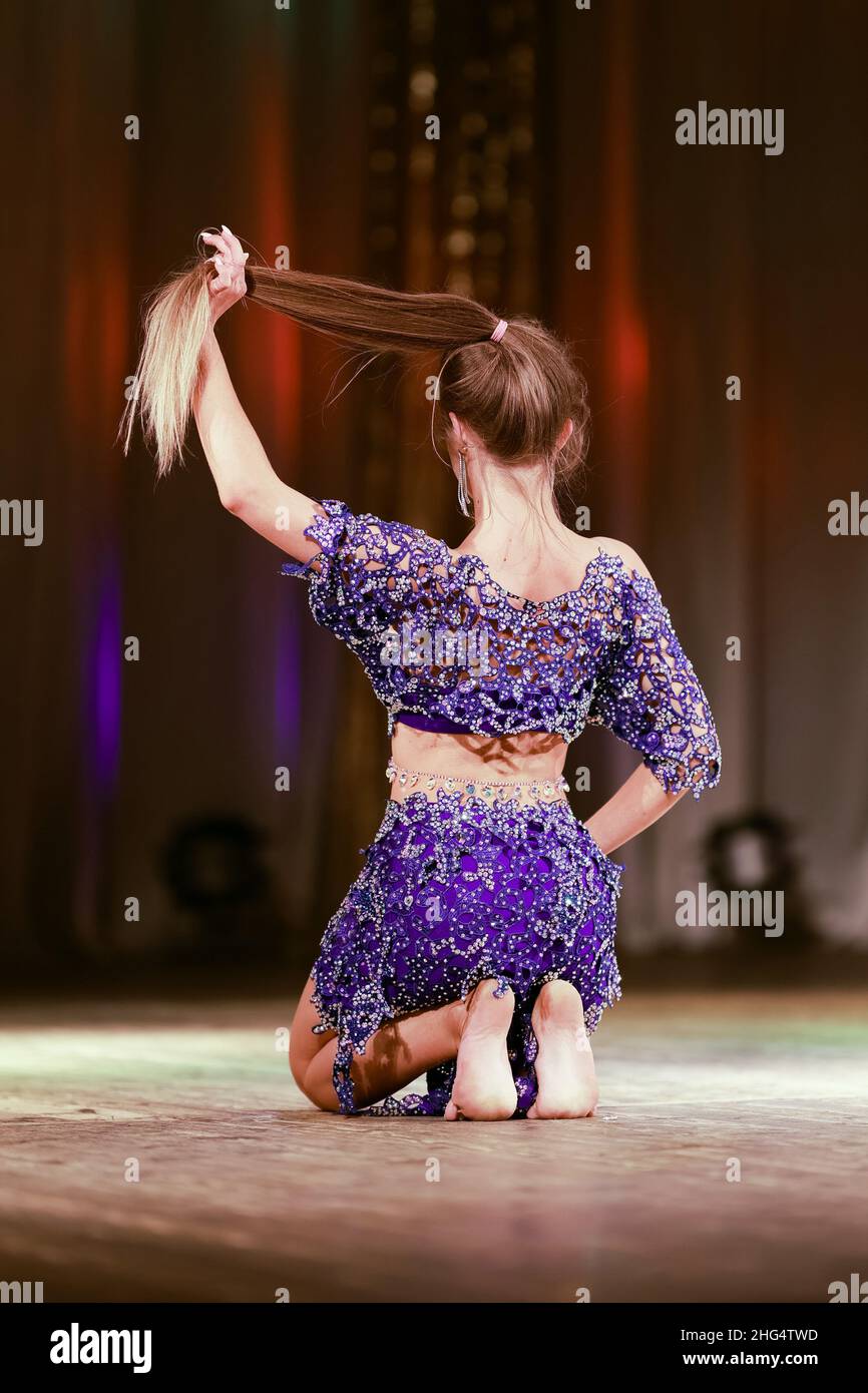 Girls dancers perform on stage with multicolored lights. Backstage
