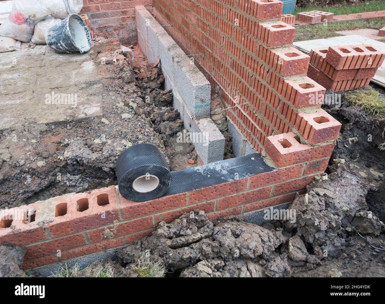 A damp proof course or membrane being applied to a brick wall. Stock Photo