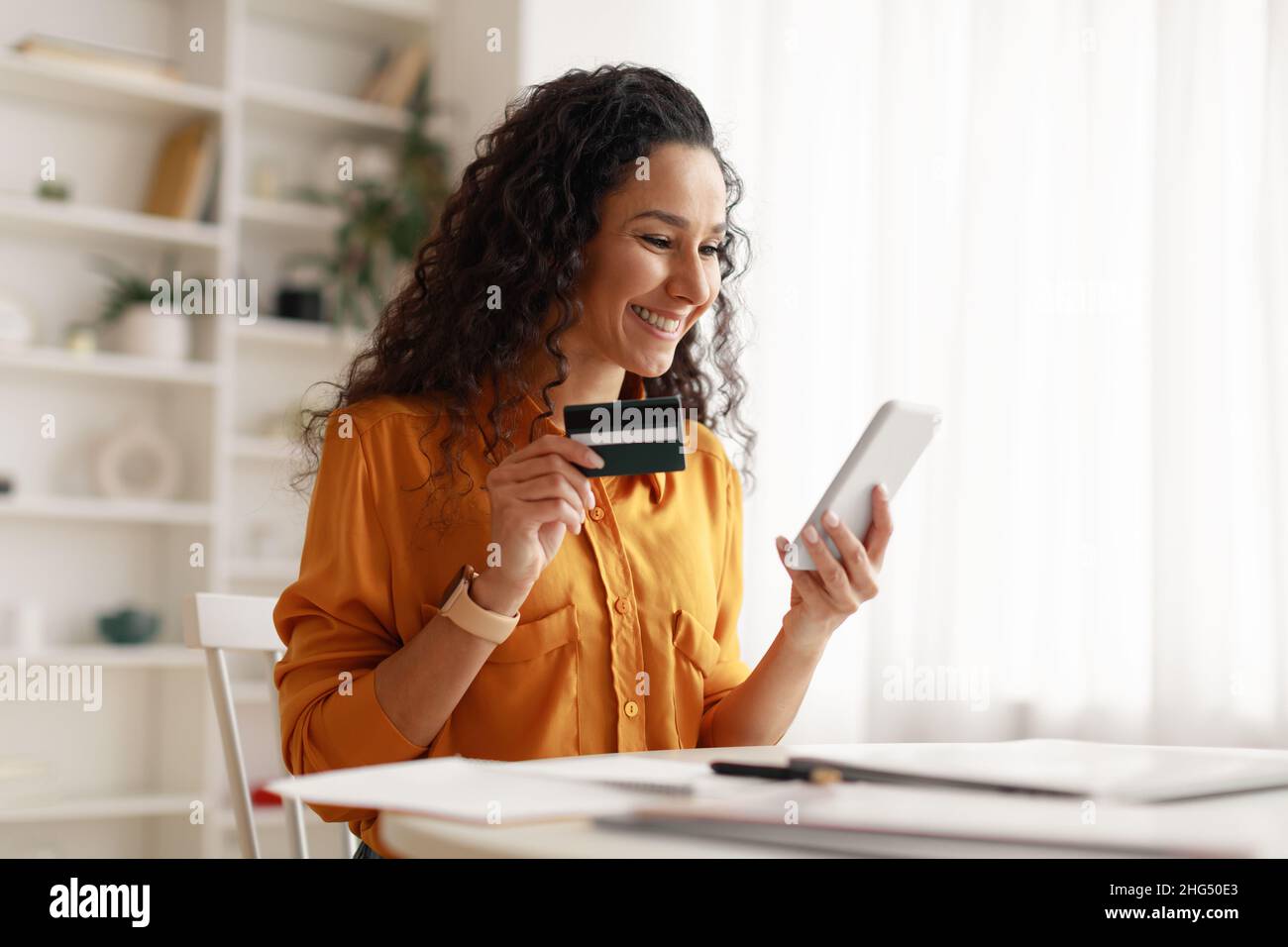 Woman Using Smartphone Shopping Online Holding Credit Card At Home Stock Photo