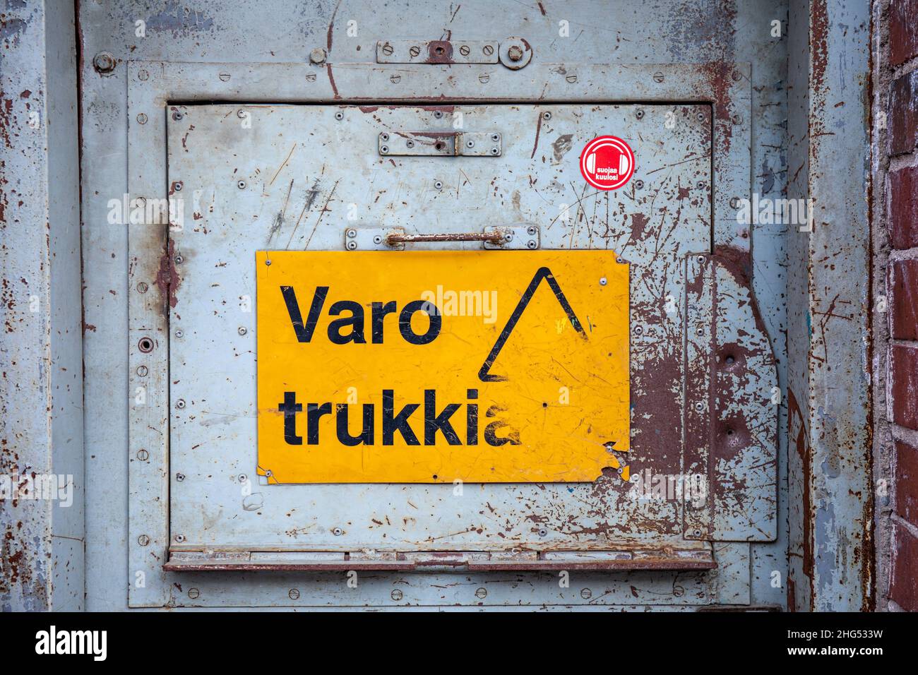 Varo trukkia. Yellow warning sign on an old metal door. Stock Photo