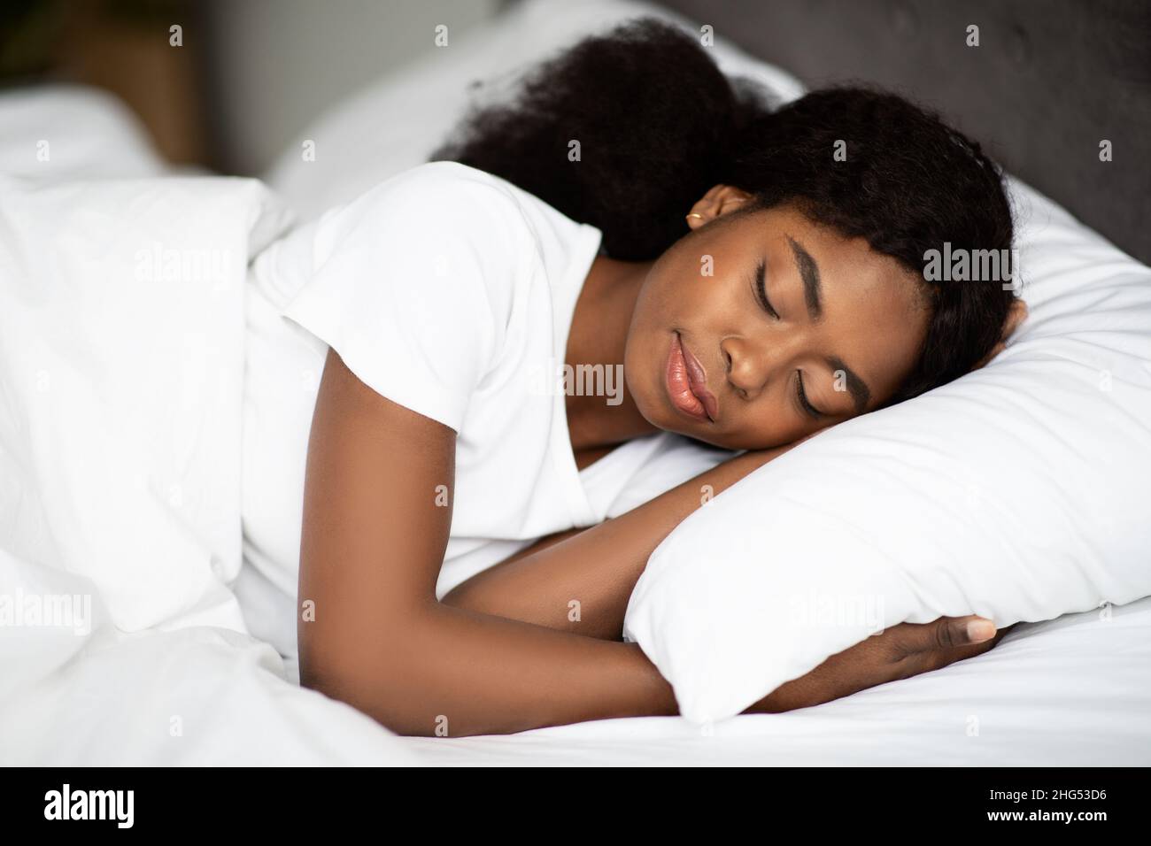 Closeup shot of young african american woman sleeping in bed Stock Photo