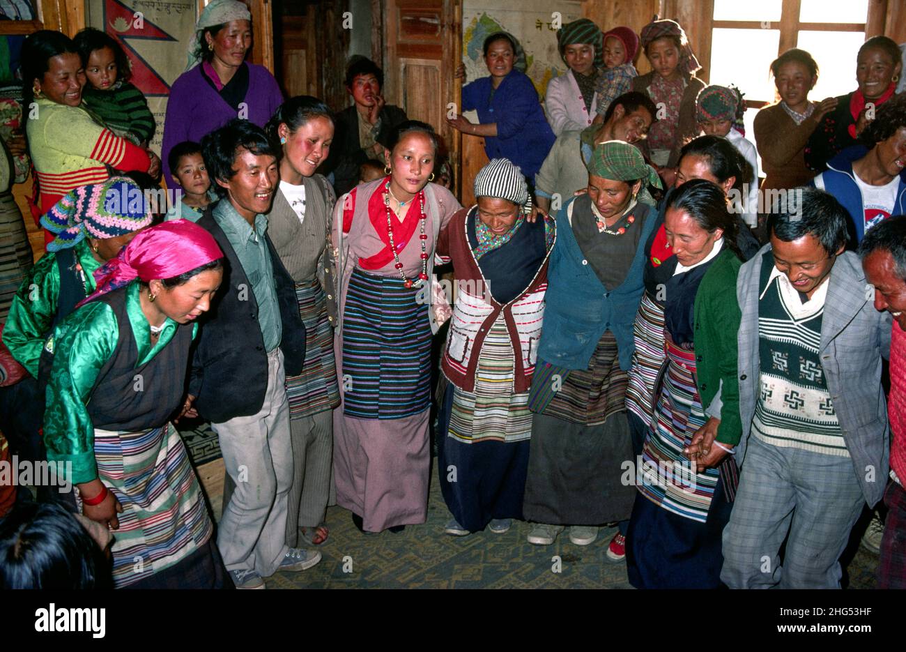 Colourful, happy Tibetan and Sherpa women in traditional dress dancing at a wedding. Solukhumbu, Nepal Stock Photo