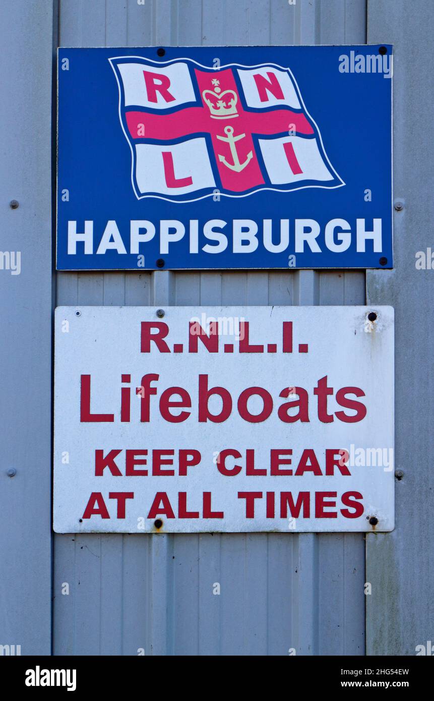 Signs outside the RNLI lifeboat shed on the North Norfolk coast at Cart Gap, Happisburgh, Norfolk, England, United Kingdom. Stock Photo