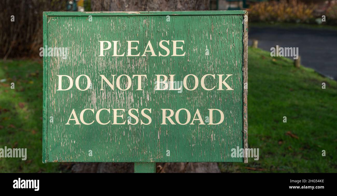 Please Do Not Block Access Road weathered wooden sign, background banner image Stock Photo
