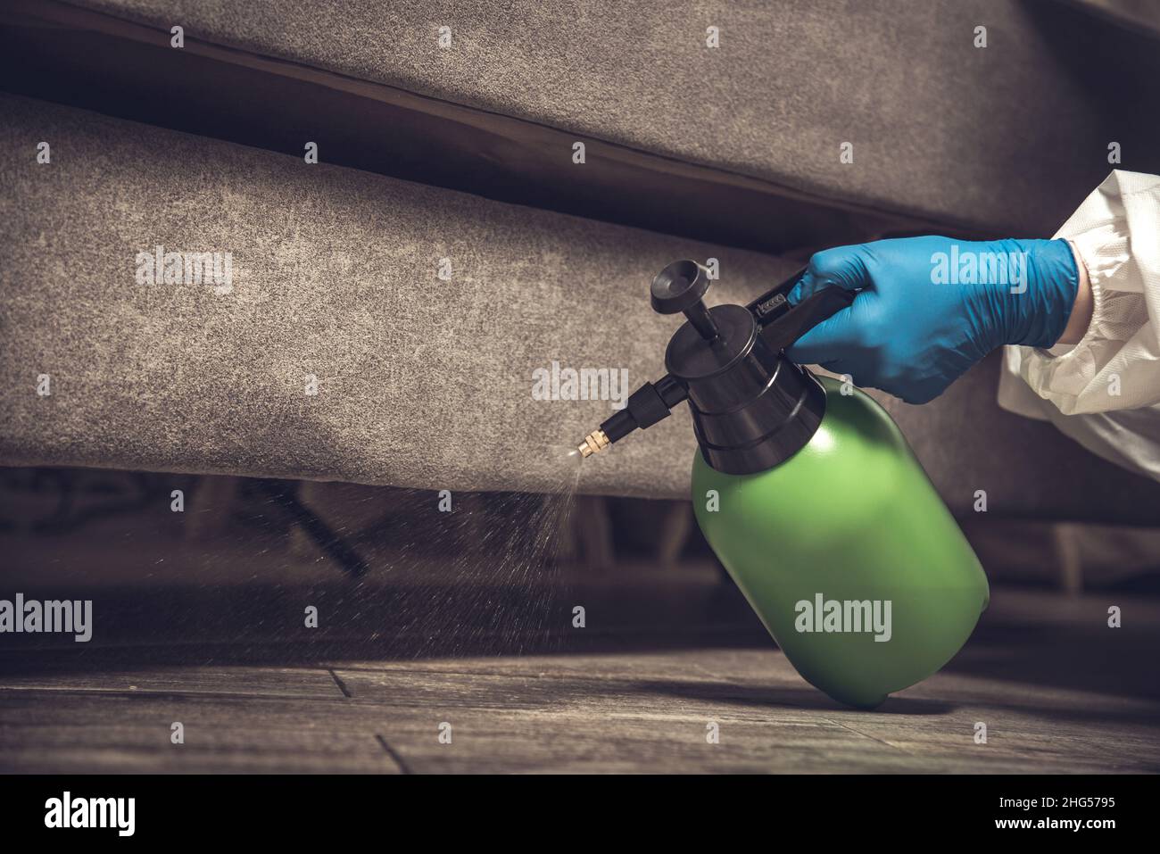 Spray gun with pesticides closeup. An exterminator in work clothes