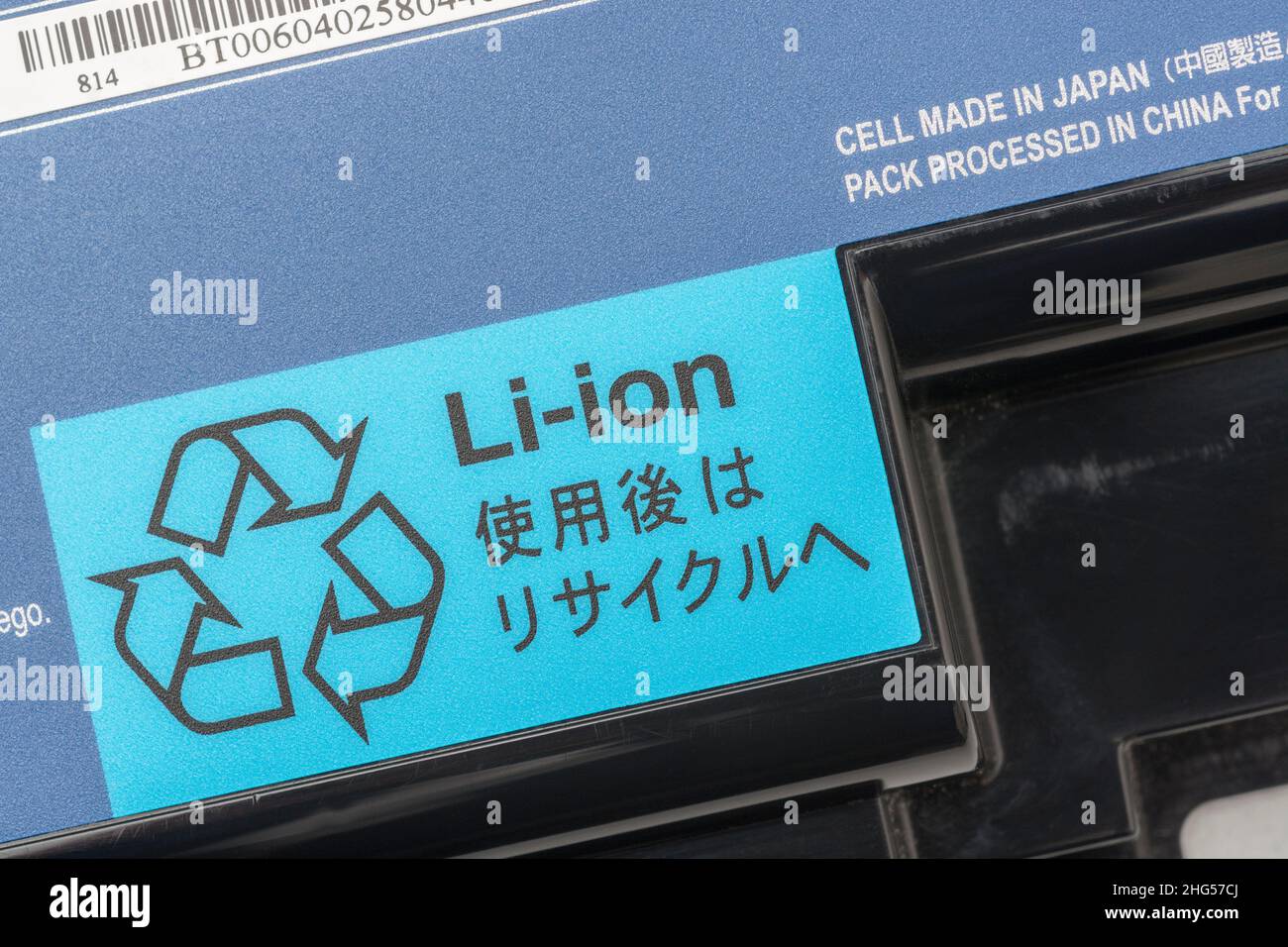 Old Lithium-ion / Li-ion laptop computer battery with Mobius Loop recycling symbol prominent. For battery recycling, hazardous materials. Stock Photo