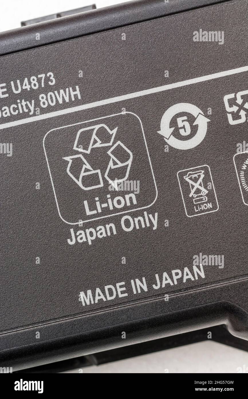 Old Lithium-ion / Li-ion laptop computer battery with Mobius Loop recycling symbol prominent. For battery recycling, Made in Japan. Stock Photo