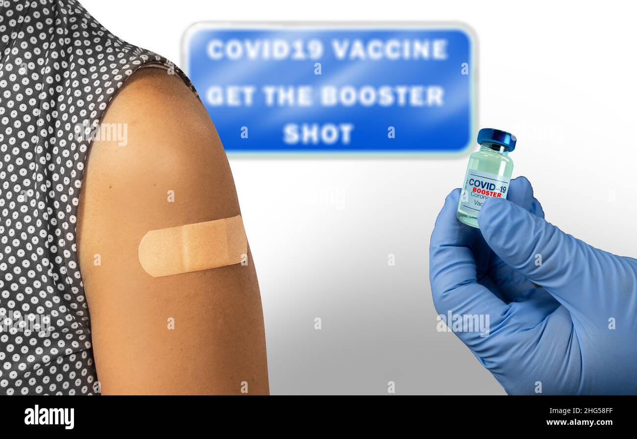 Vaccination clinic for covid 19 vaccine booster shot. A patient and the booster vaccine bottle. Sign with 'Covid-19 Vaccine Get the Booster shot'. Stock Photo