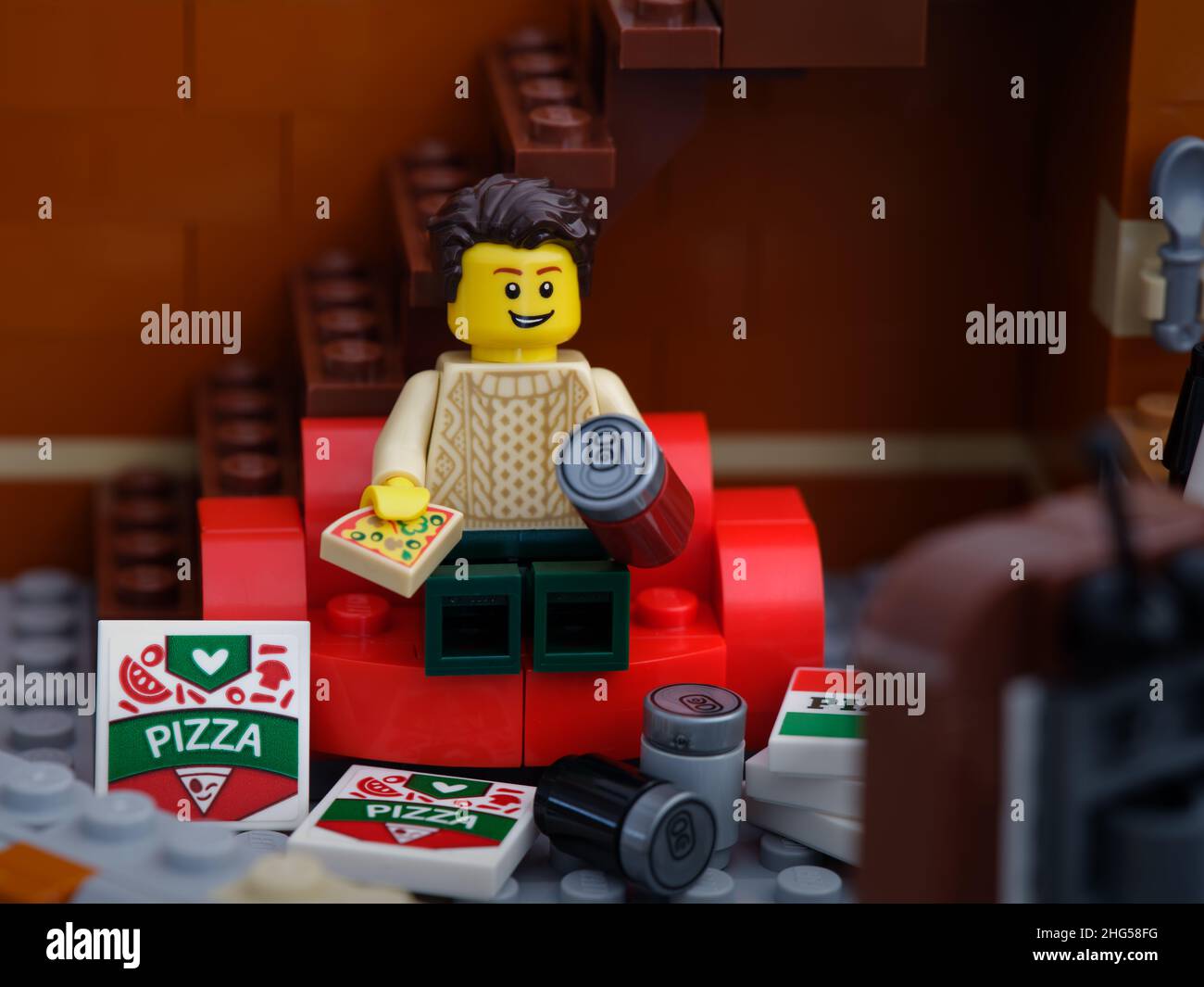 Tambov, Russian Federation January 03, A Lego man sitting on red couch eating a pizza and watching television with pizza boxes and soda cans Stock Photo - Alamy