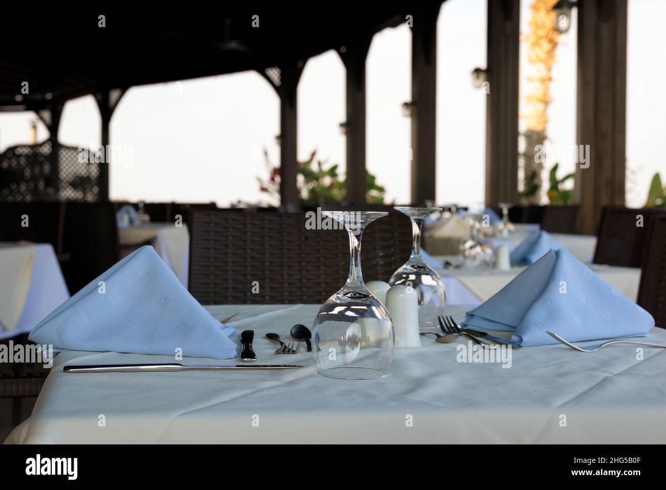 Tables in Greek taverna with galsses and cutlery ready for guests Stock Photo