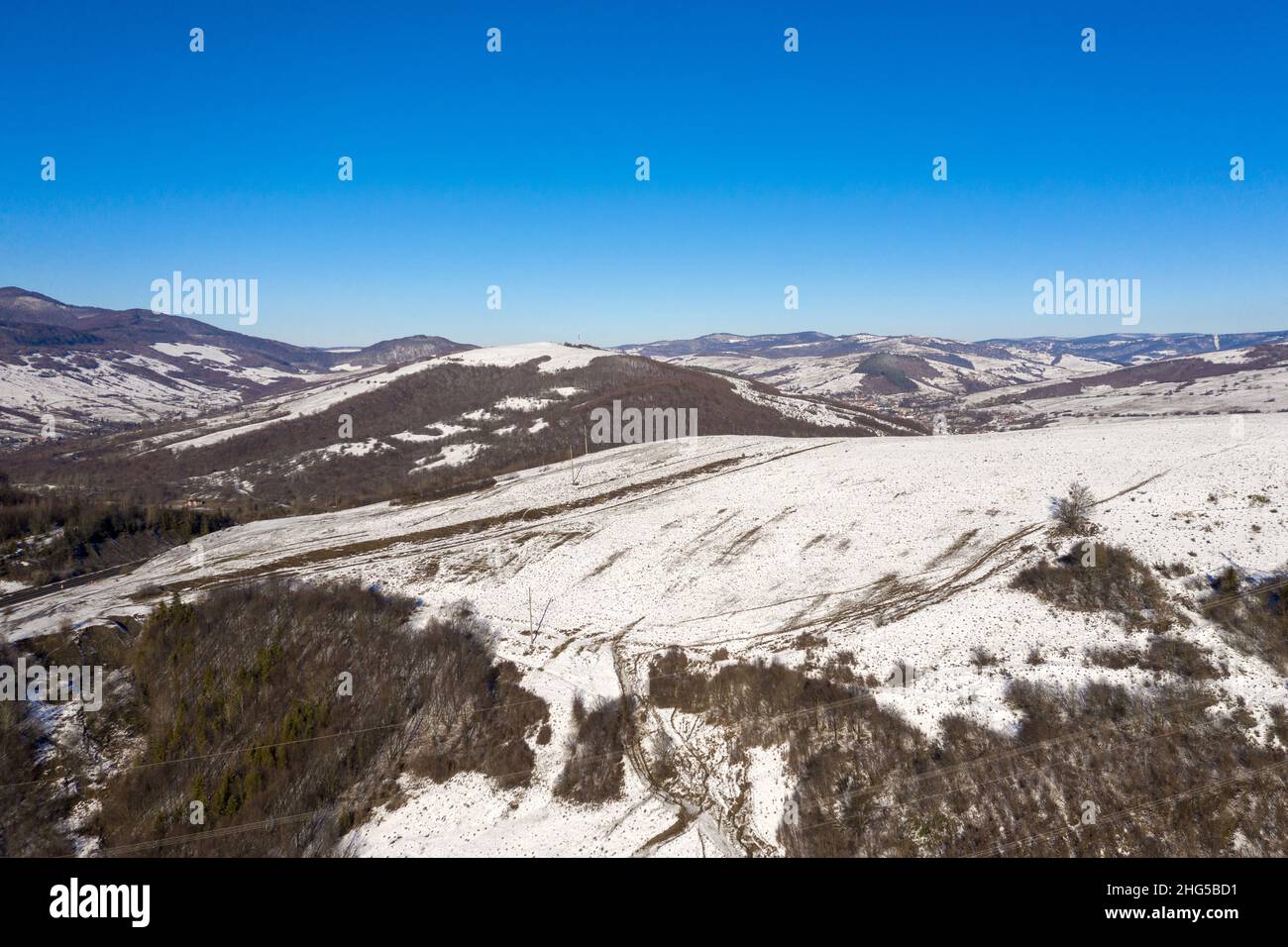 High voltage power lines in the mountains in wintertime aerial view ...