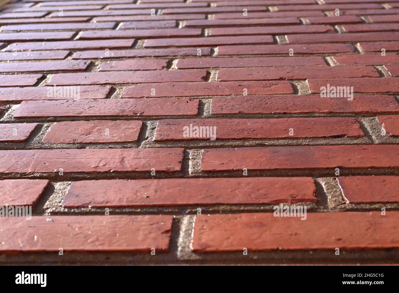 Perspective red shiny brick wall, wide panorama of masonry, bricklaying
